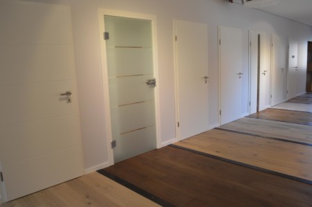 Glastüren und weiße Holztüren mit unterschiedlichen Bodenbelägen